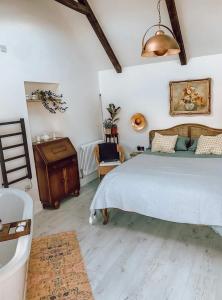um quarto com uma cama grande e piso em madeira em Priory Cottage Stables em Cowden