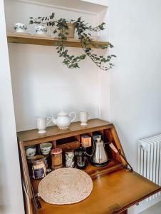a shelf with a tea kettle and other items on it at Priory Cottage Stables in Cowden
