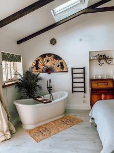 a bathroom with a bath tub in a bedroom at Priory Cottage Stables in Cowden