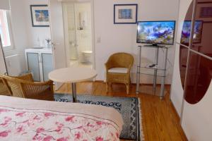 a bedroom with a bed and a television and a table at Landgasthof Kirschgarten in Ingelheim am Rhein