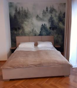 een bed in een slaapkamer met een schilderij aan de muur bij Apartament Szklar-Ski in Szklarska Poręba