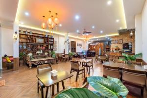 un restaurante con mesas y sillas en una habitación en La An Old Town Hotel, en Hoi An