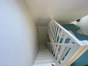 escalera blanca en una habitación con cama en Près des etoiles, en Dieppe
