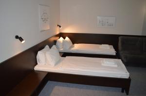 een hotelkamer met 2 bedden en een bank bij MotelChuk in Ivano-Frankivsʼk