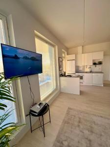 a living room with a flat screen tv on a wall at New 3-Bed Apartment & Free Garage parking & PS5 in Vantaa