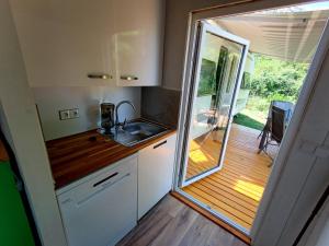 a kitchen with a sink and a door to a deck at landhaus-krk in Batomalj