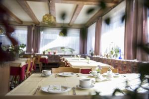 una sala da pranzo con tavoli, sedie e finestre di Sonnenberg a Silandro