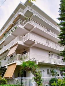 un edificio de apartamentos con balcones blancos y árboles en Νέο ανακαινισμένο διαμέρισμα 70τμ στο Μαρούσι, en Atenas