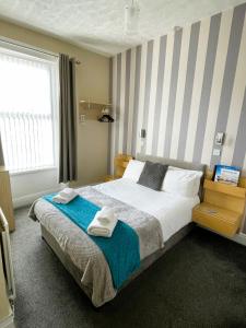 1 dormitorio con 1 cama grande y toallas. en The Berkeley Morecambe, en Morecambe