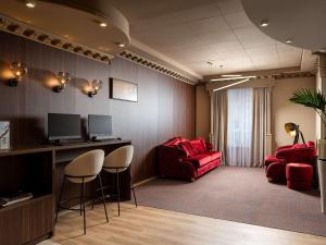 a waiting room with two red chairs and a desk at Mercure Chisinau Center Jazz Hotel in Chişinău
