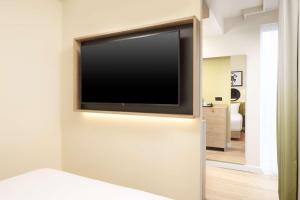 uma televisão de ecrã plano numa parede num quarto em Hampton By Hilton London Old Street em Londres