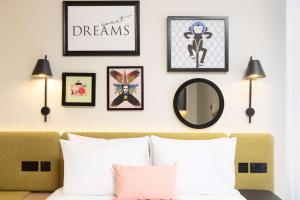 a room with a bed and framed pictures on the wall at Hampton By Hilton London Old Street in London
