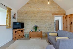 a living room with a couch and a tv at Fox in Charlbury