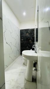 a white bathroom with a sink and a tub at The heaven(close to golden temple) in Amritsar