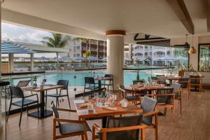 a restaurant with a pool and tables and chairs at Hilton Cancun Mar Caribe All-Inclusive Resort in Cancún