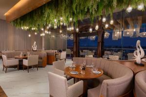 a restaurant with tables and chairs and chandeliers at Hilton Cancun Mar Caribe All-Inclusive Resort in Cancún