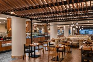 a restaurant with wooden tables and chairs and a bar at Hilton Cancun Mar Caribe All-Inclusive Resort in Cancún
