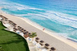 an aerial view of a beach with umbrellas and the ocean at Hilton Cancun Mar Caribe All-Inclusive Resort in Cancún