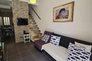 a living room with a couch and a staircase at NEW!! 1 Bedroom Center Tavira - R. Freiras in Tavira
