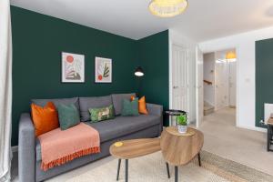 a living room with a gray couch and a green wall at Modern 2-Bed Townhouse in Kirkdale in Liverpool