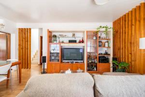 uma sala de estar com um sofá e uma televisão em Jose & Ester House em Almada