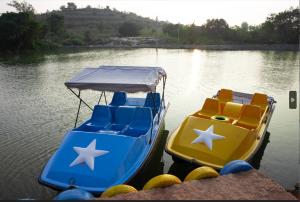 two boats sitting on a body of water at Lake Valley Resort and Spa Tirupati in Tirupati