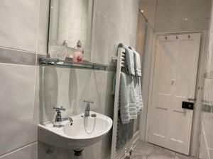 a white bathroom with a sink and a mirror at Mill House Bed and Breakfast in Cromer +14 photos