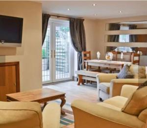 een woonkamer met een bank en een tafel bij Surrounded by fields just 3 miles from Stratford - upon Avon - Alveston Pastures Cottage in Stratford-upon-Avon