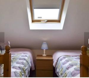 a bedroom with two twin beds and a window at Surrounded by fields Alveston Pastures Cottage in Stratford-upon-Avon