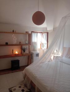 een slaapkamer met een bed met een witte sprei en een raam bij Affittacamere la Casella Monteriggioni in Monteriggioni