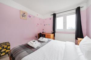 a bedroom with a large bed with towels on it at Penthouse 1BR flat wbalcony & city view, Walworth in London