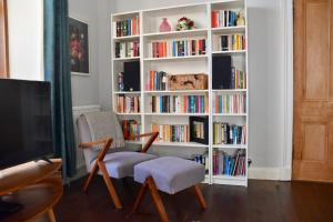 a living room with a book shelf filled with books at Vibrant 1BD flat with Garden in Dunfermline, Fife in Dunfermline