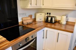 a kitchen with a counter top with a microwave at Vibrant 1BD flat with Garden in Dunfermline, Fife in Dunfermline