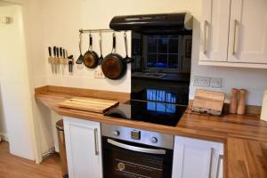 a kitchen with a stove and a counter top at Vibrant 1BD flat with Garden in Dunfermline, Fife in Dunfermline