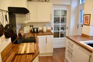 a kitchen with white cabinets and a counter top at Vibrant 1BD flat with Garden in Dunfermline, Fife in Dunfermline