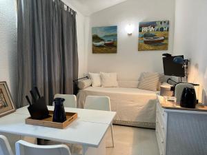 a small room with a bed and a table and chairs at Domus Tom Apartment with sea view Villasimius in Simius