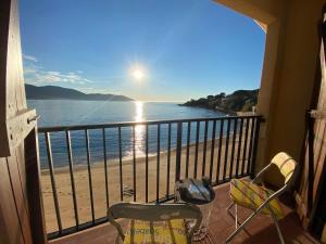balcón con vistas a la playa y al océano en Studio pieds dans l'eau TIUCCIA, en Casaglione