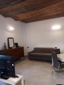 salon z kanapą i stołem w obiekcie Casa Sant'Eurosia, immergiti nella Maremma Toscana w mieście Principina Terra