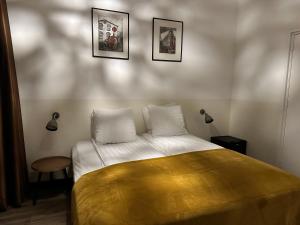 ein Schlafzimmer mit einem Bett mit drei Bildern an der Wand in der Unterkunft Hotel Buren in West-Terschelling