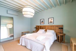 a bedroom with a large bed with white sheets at Guava Azores in Ribeira das Tainhas +23 photos