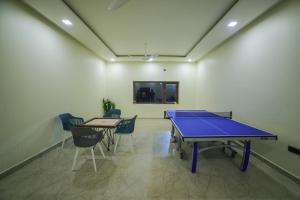 a ping pong table in a room with chairs at Lake Valley Resort and Spa Tirupati in Tirupati