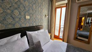 a bedroom with a bed with white sheets and a mirror at Residence Dream in Rovinj