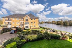 una imagen de un gran edificio al lado de un río en Beautiful Penthouse Apartment, en Walton-on-Thames