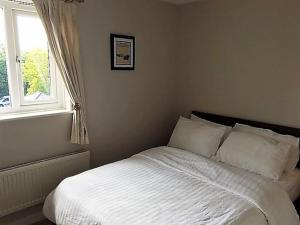 una camera con un letto bianco e una finestra di Beautiful Penthouse Apartment a Walton-on-Thames