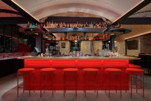 a bar with red bar stools in a room at Ribas Rooms Ferenc Lviv in Lviv
