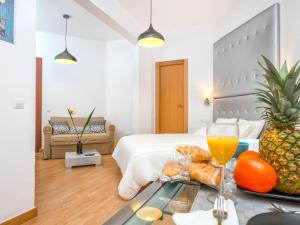 a hotel room with a bed with a tray of food at Magnifico Estudio en Bolsa 6. AC. in Málaga