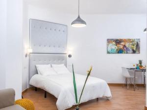 a bedroom with a white bed and a table at Magnifico Estudio en Bolsa 6. AC. in Málaga