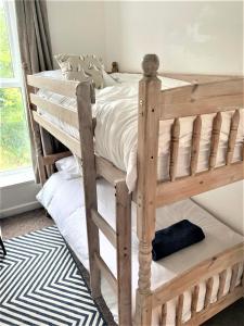 ein Etagenbett aus Holz in einem Schlafzimmer in der Unterkunft The Captain's Lodge Looe in Looe