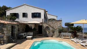 une villa avec piscine devant une maison dans l'établissement Villa Ghjunchitu - Vue mer et Piscine privée proche de l'ile rousse, à Corbara
