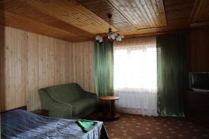 a bedroom with a bed and a chair and a window at Gutsulochka Apartment in Yaremche